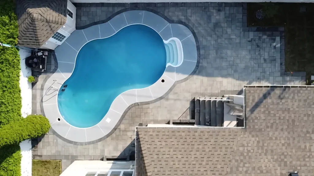 Vue aérienne d'un contour de piscine en pavé uni dans le Grand Montréal