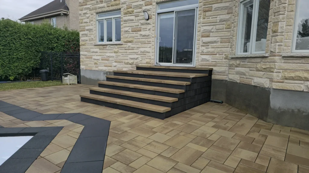 Terrasse en pavé uni avec marches intégrées près d’une piscine